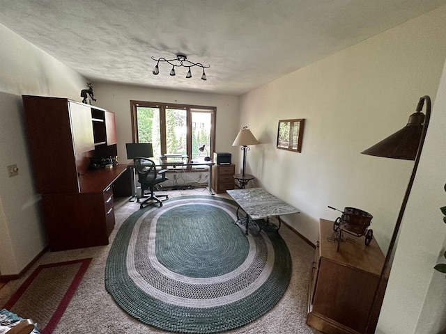 office space with light carpet, a textured ceiling, and baseboards