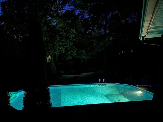 pool at night featuring an outdoor pool