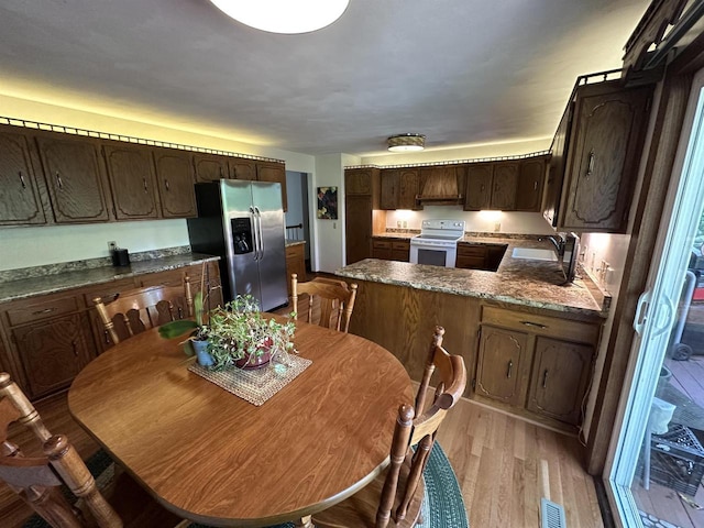 dining space with light wood-type flooring and visible vents