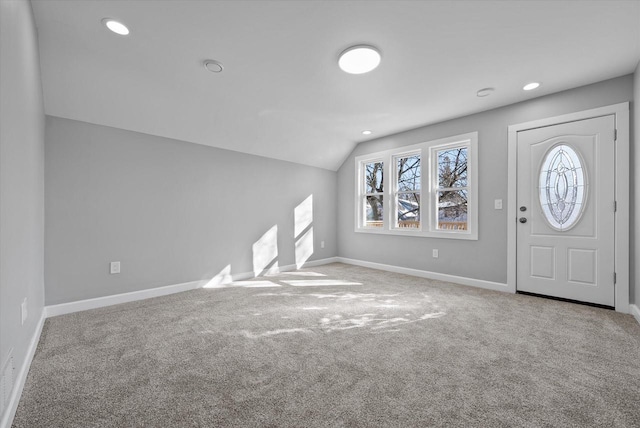 foyer entrance with recessed lighting, light carpet, vaulted ceiling, and baseboards