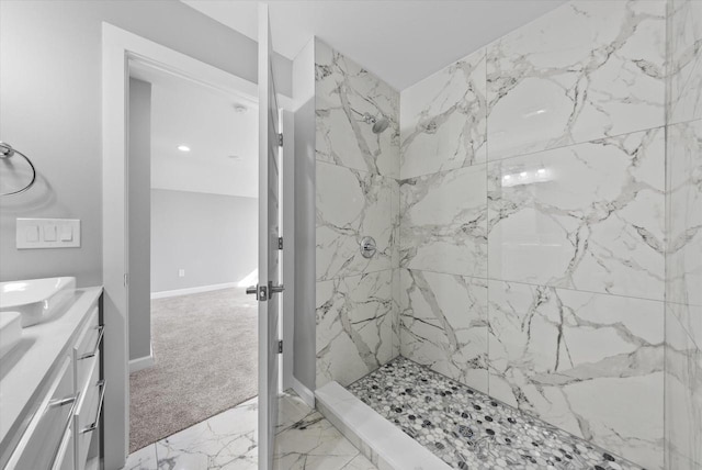 bathroom featuring double vanity, marble finish floor, a marble finish shower, and baseboards