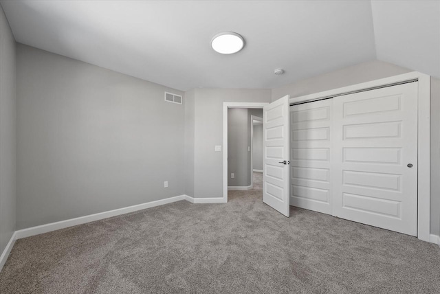 unfurnished bedroom with a closet, carpet, visible vents, and baseboards