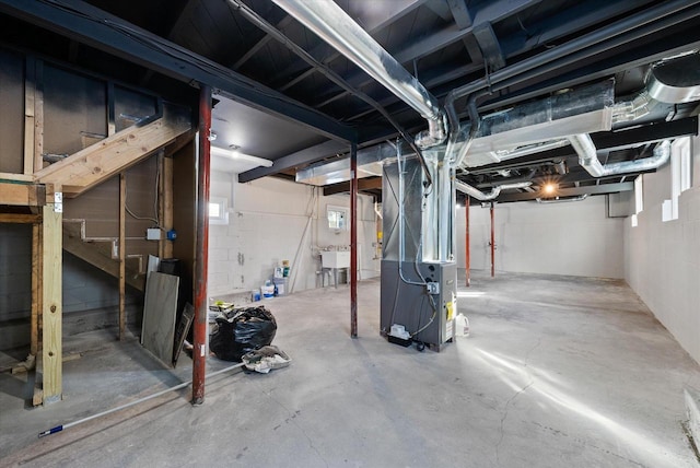 basement featuring stairway, a sink, and heating unit