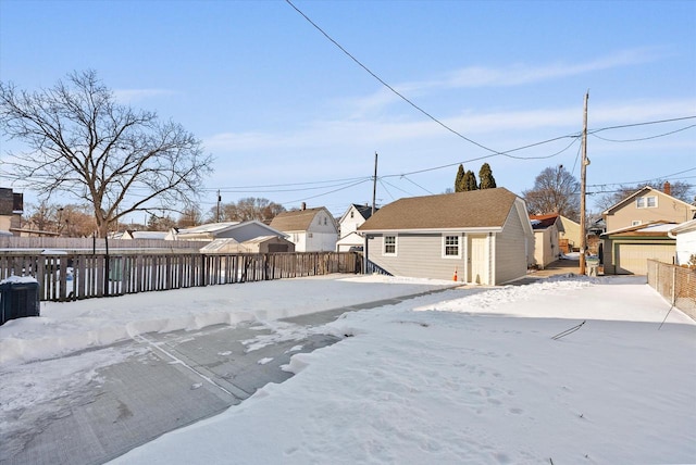 view of front facade featuring a garage, a residential view, fence, and an outdoor structure