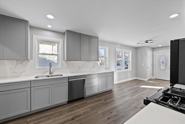 kitchen with a sink, light countertops, and dishwasher