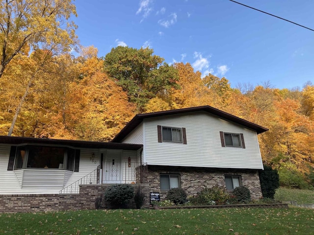 view of front of house featuring brick siding and a front yard