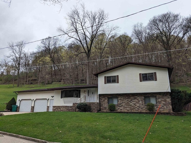 split level home with a garage, driveway, a front lawn, and brick siding