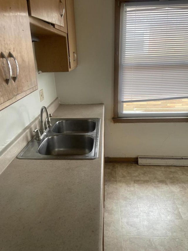 kitchen featuring a baseboard heating unit and a sink