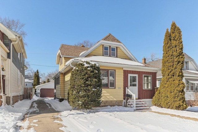 view of front of property with a garage, roof with shingles, a chimney, and entry steps