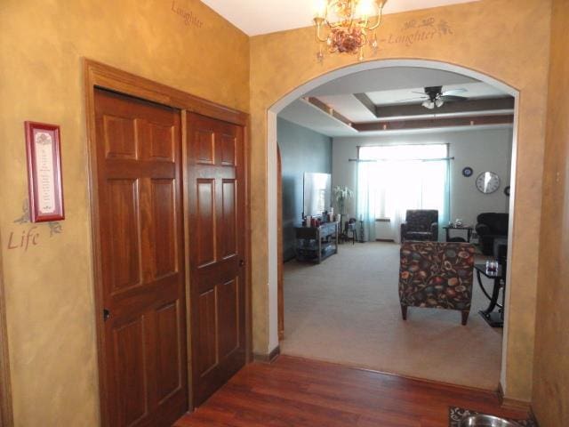 N5194 Blue Valley Rd, Hartford, WI 53027 - hallway with arched walkways, a raised ceiling, wood finished floors, carpet flooring, and a chandelier