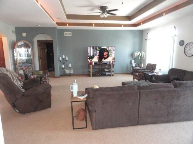 N5194 Blue Valley Rd, Hartford, WI 53027 - carpeted living area featuring arched walkways, a ceiling fan, and a tray ceiling