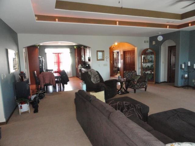N5194 Blue Valley Rd, Hartford, WI 53027 - living room featuring arched walkways, light carpet, and a raised ceiling