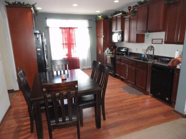 N5194 Blue Valley Rd, Hartford, WI 53027 - kitchen featuring black appliances, a sink, dark countertops, light wood-style floors, and recessed lighting