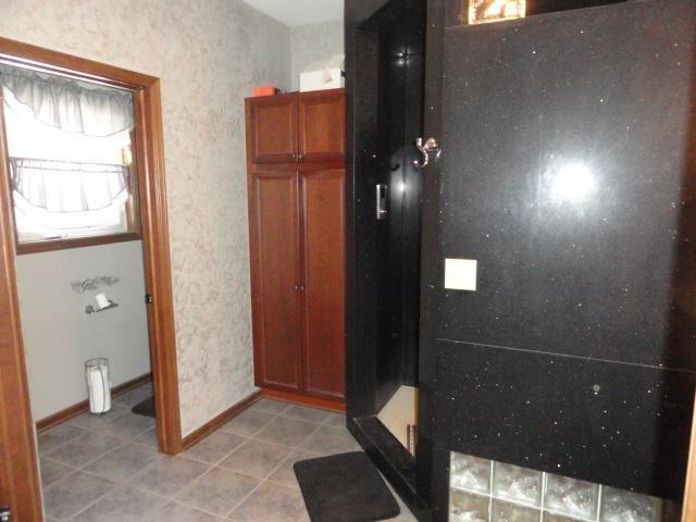 N5194 Blue Valley Rd, Hartford, WI 53027 - full bath featuring a stall shower, tile patterned flooring, and baseboards