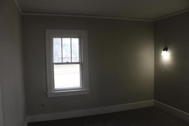 empty room featuring crown molding and baseboards