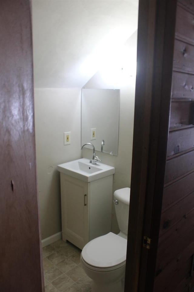 bathroom featuring baseboards, vanity, and toilet