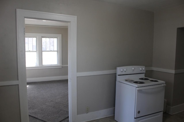 kitchen with electric range, carpet, and baseboards