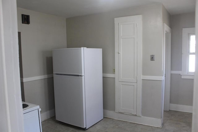 kitchen with light countertops, white appliances, and baseboards