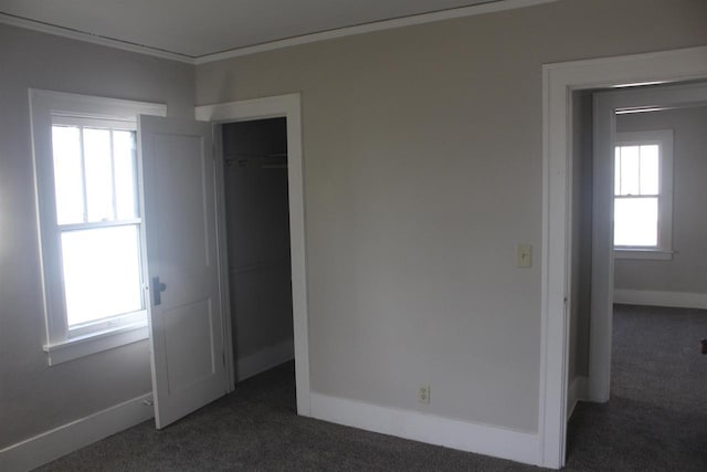 unfurnished bedroom with a closet, dark carpet, and baseboards