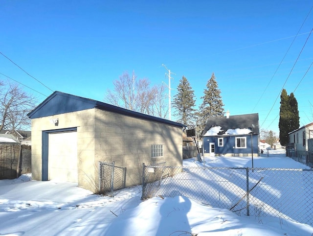 exterior space with an outbuilding, a detached garage, and fence