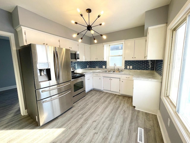 kitchen with visible vents, light countertops, appliances with stainless steel finishes, and white cabinetry