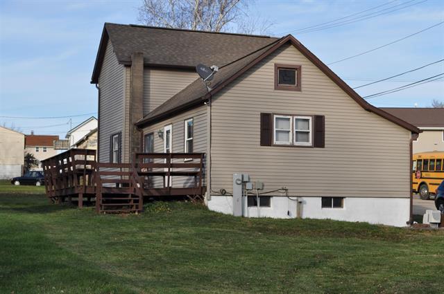 back of property featuring a yard and a wooden deck