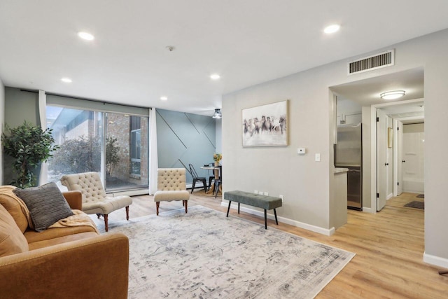 living area featuring light wood-style flooring, visible vents, baseboards, and recessed lighting