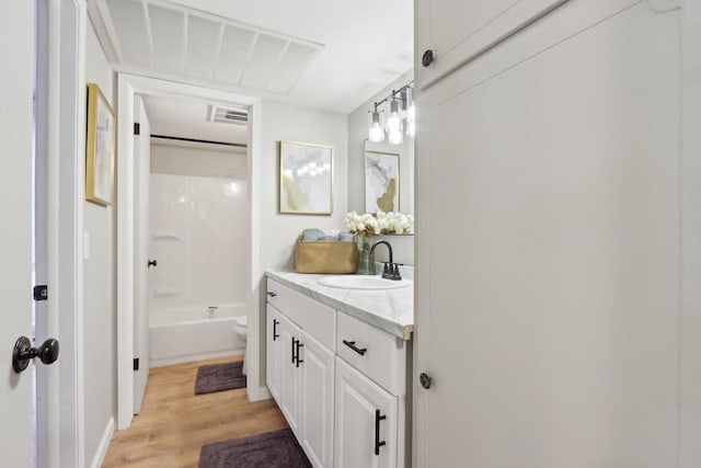 bathroom featuring shower / bath combination, visible vents, toilet, vanity, and wood finished floors