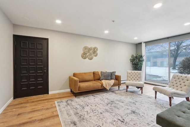 living area featuring light wood-type flooring, a baseboard heating unit, baseboard heating, and recessed lighting