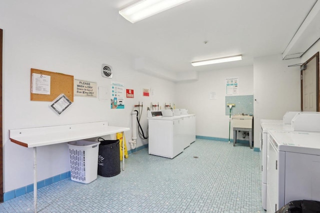 shared laundry area featuring washing machine and dryer and baseboards