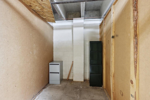 interior space featuring concrete block wall and concrete floors