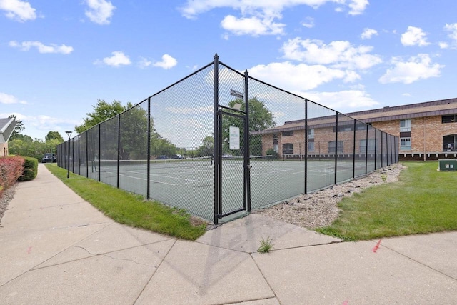 view of sport court with a lawn and fence