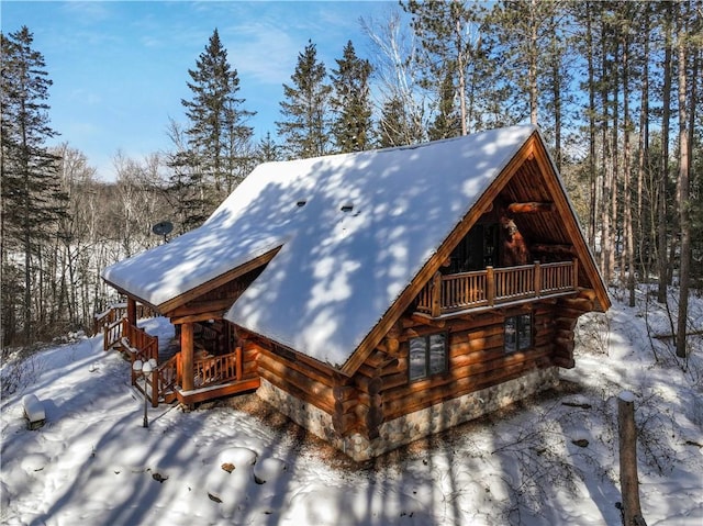 view of snow covered exterior featuring log exterior