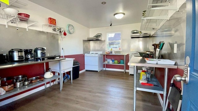 kitchen with under cabinet range hood, range, and dark wood-style flooring