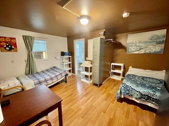 bedroom featuring light wood-type flooring and cooling unit