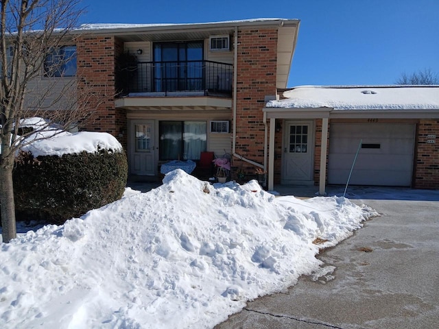 view of front of property featuring brick siding, driveway, and a garage