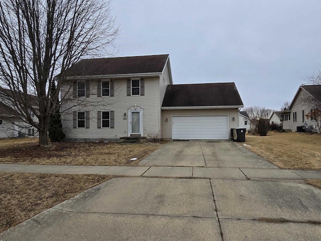 colonial home with a garage, concrete driveway, and entry steps