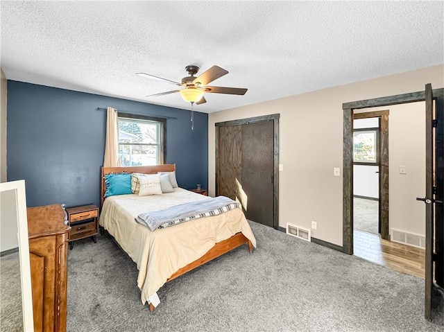 bedroom featuring dark carpet, a closet, visible vents, and ceiling fan