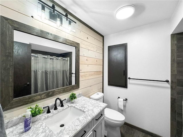 bathroom featuring toilet, a shower with curtain, vanity, and wooden walls