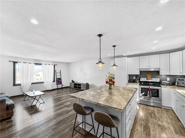 kitchen featuring pendant lighting, electric stove, white cabinets, a kitchen island, and under cabinet range hood