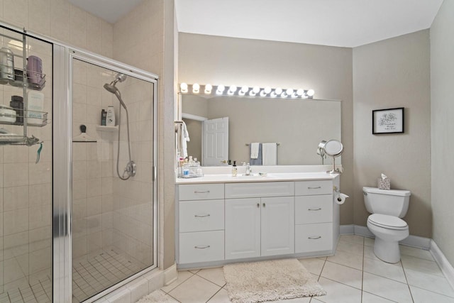 bathroom with toilet, a shower stall, vanity, and tile patterned floors