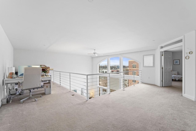 carpeted office with ceiling fan and baseboards