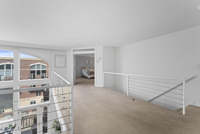 corridor featuring carpet flooring and an upstairs landing