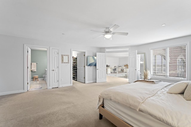 bedroom with light carpet, ensuite bath, a ceiling fan, and baseboards