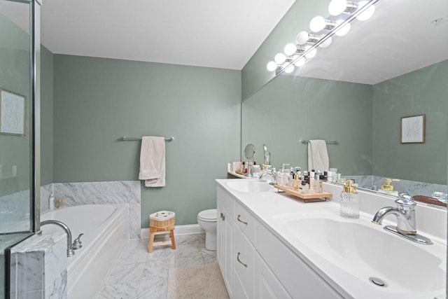 bathroom featuring marble finish floor, a garden tub, a sink, and toilet