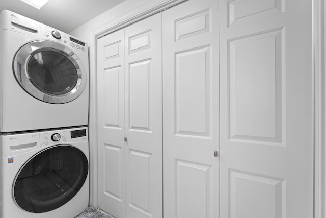 clothes washing area with stacked washer and dryer and laundry area