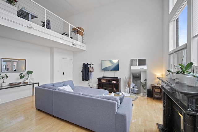 living room with light wood-style floors and a high ceiling