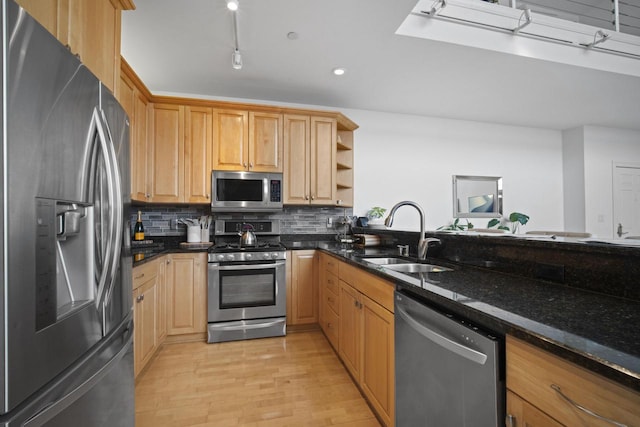 kitchen featuring a sink, light wood-style floors, appliances with stainless steel finishes, open shelves, and tasteful backsplash