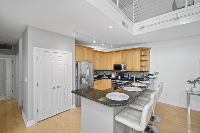 kitchen with tasteful backsplash, visible vents, appliances with stainless steel finishes, light wood-type flooring, and open shelves