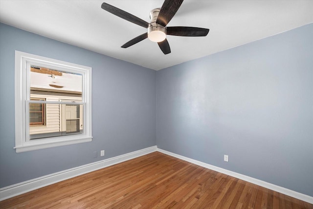 spare room featuring ceiling fan, baseboards, and wood finished floors